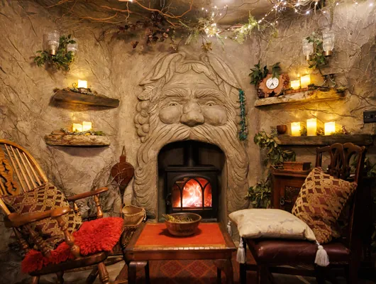 The carved fireplace glowing inside Faun's Hideaway
