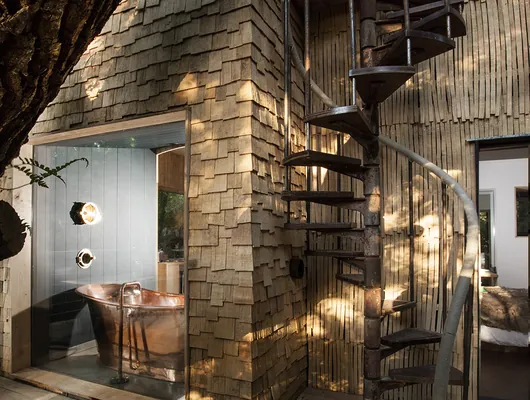 The spiral staircase winding down from the treehouse deck