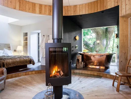 The rotating wood burner and roll-top bath inside the Woodsman's Treehouse