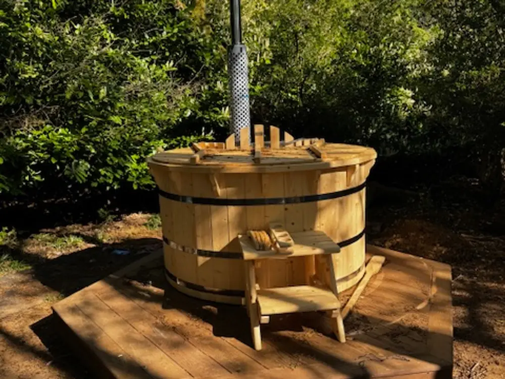 The wood-fired hot tub among the trees