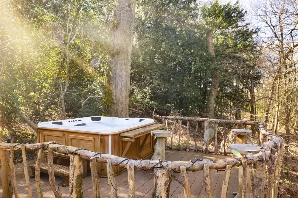 The electric jacuzzi on its deck among the trees